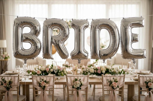 A beautifully decorated bridal shower featuring a tiara, elegant sashes, and bride balloons, by Joycraft.
