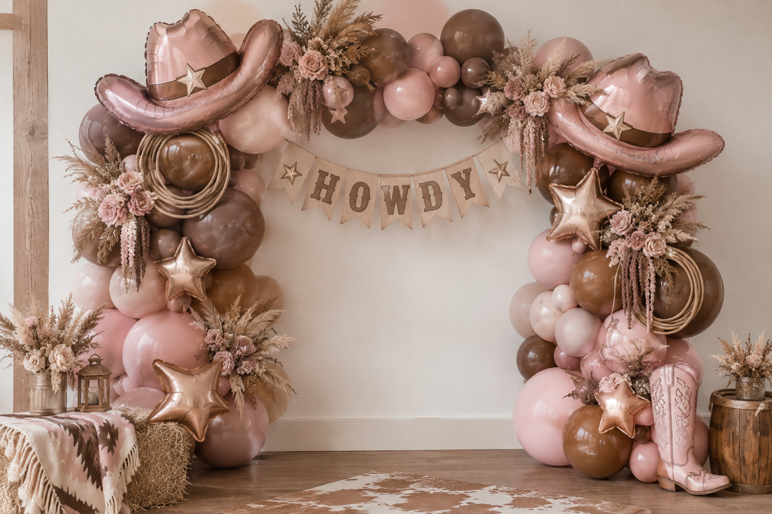 Dusty pink and brown balloon garland framing a cowgirl birthday cake table with western party details.